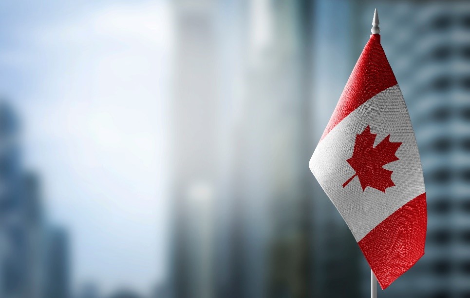 Canadian flag in the foreground of a blurry cityscape